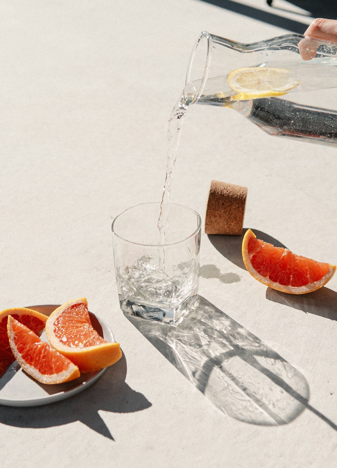 sliced orange fruit beside clear drinking glass
