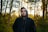 man in black hoodie standing in forest during daytime