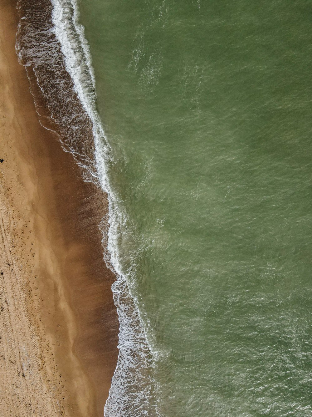 aerial view of ocean waves on shore during daytime