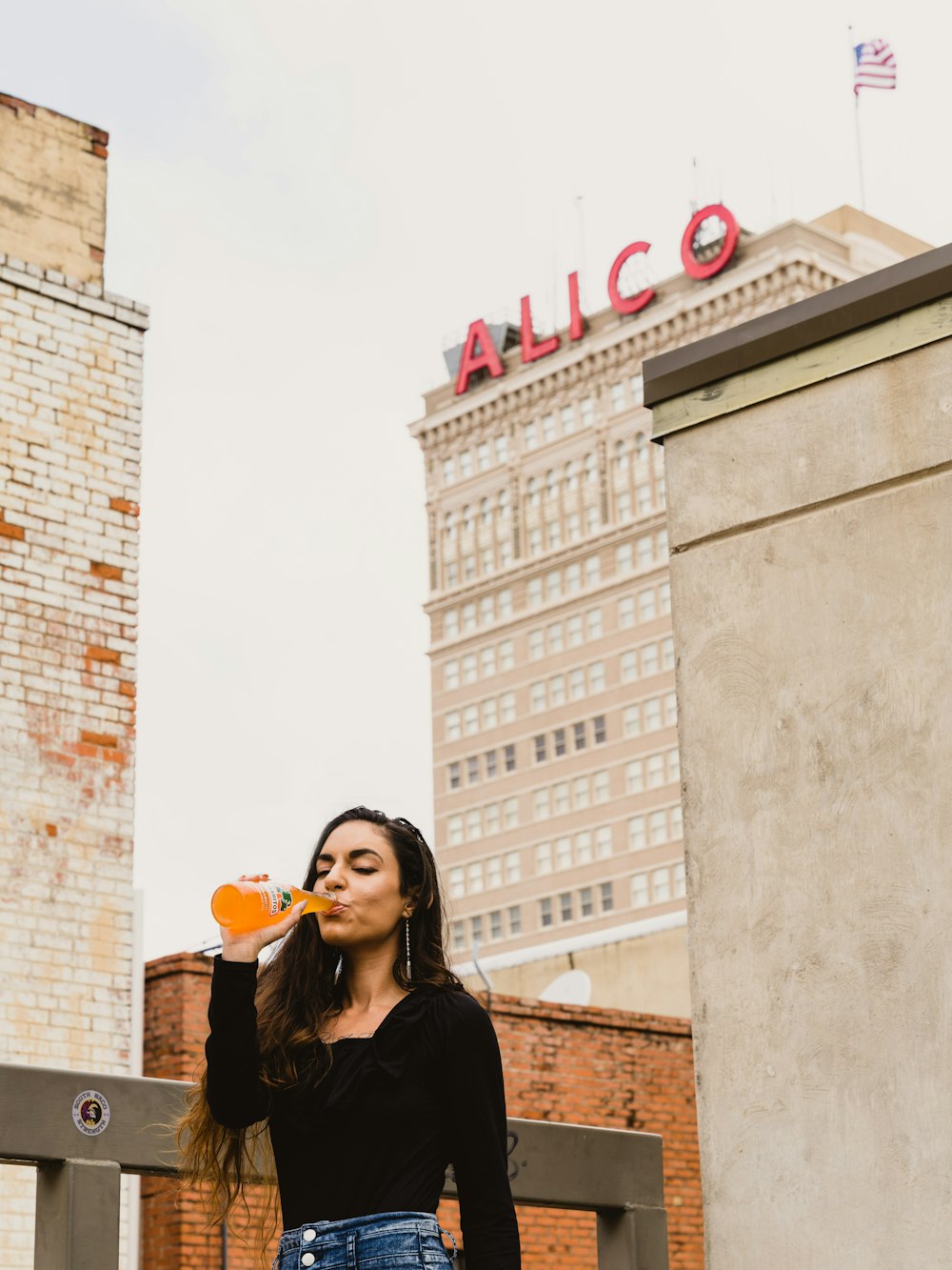 woman in black long sleeve shirt holding orange heart balloon