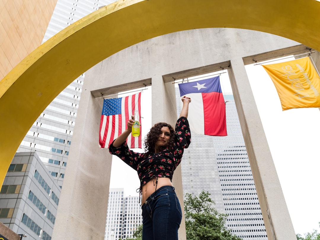 woman in black shirt and blue denim jeans raising her hands