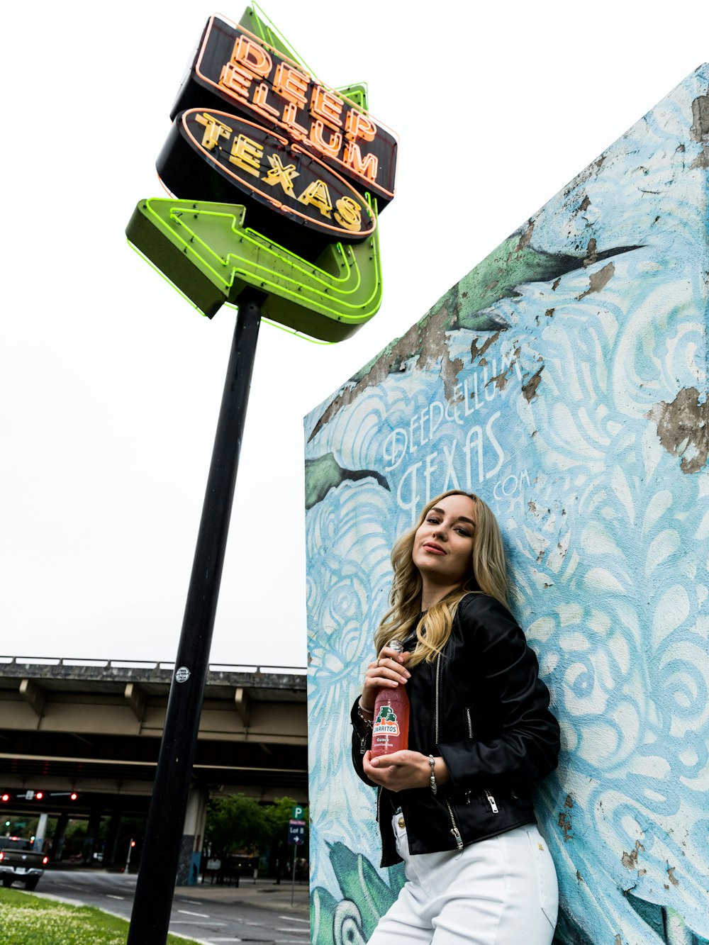 woman in black leather jacket holding coca cola bottle