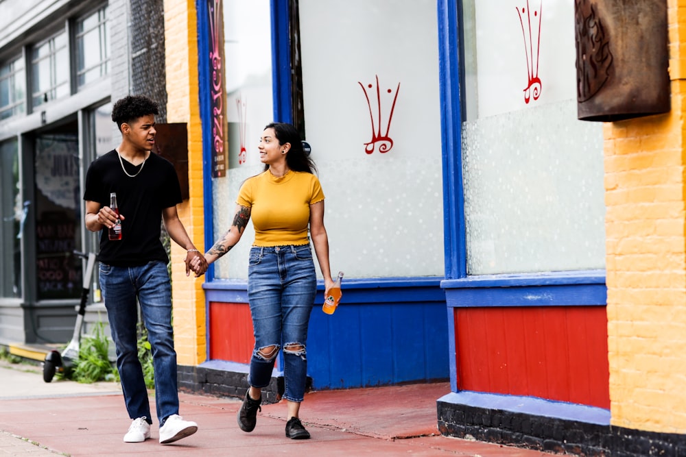 man in yellow crew neck t-shirt standing beside woman in black t-shirt