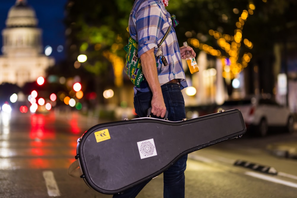 man in green white and black plaid button up shirt playing black guitar