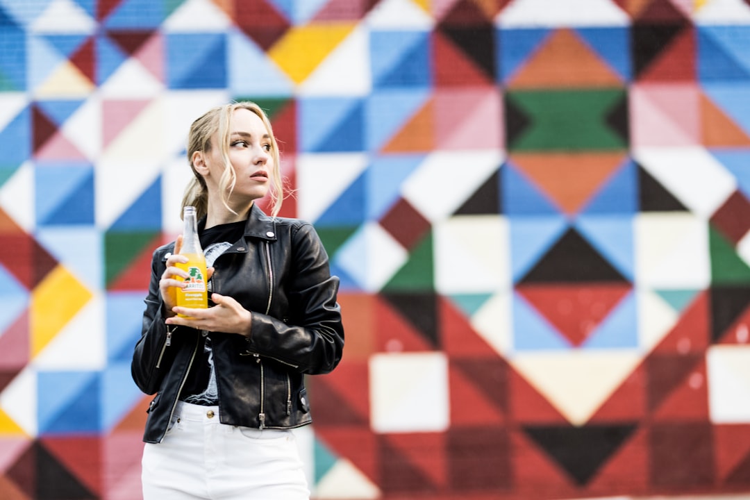 girl in black leather jacket holding yellow and orange plastic toy