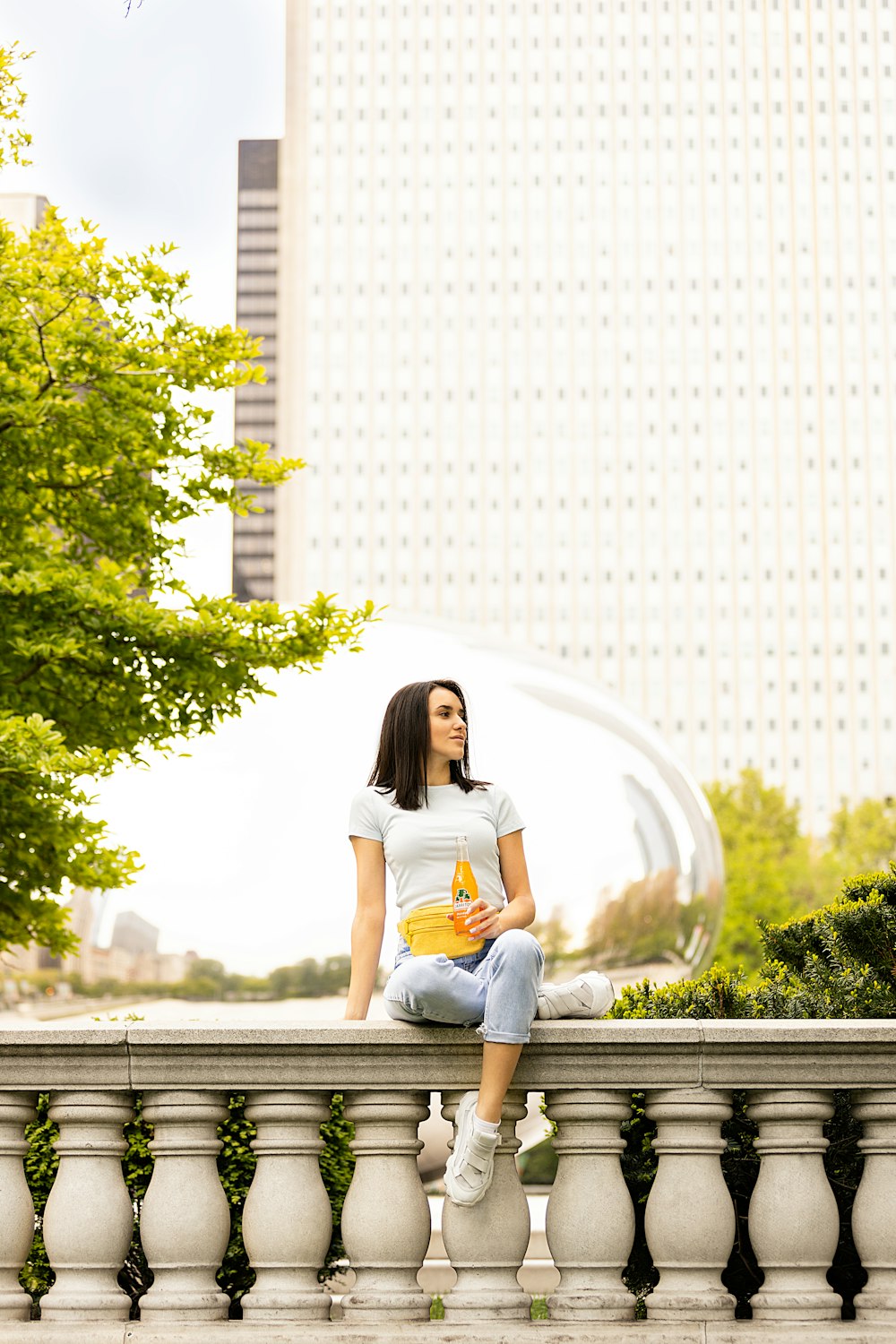 Femme en chemise blanche assise sur un banc en bois gris pendant la journée