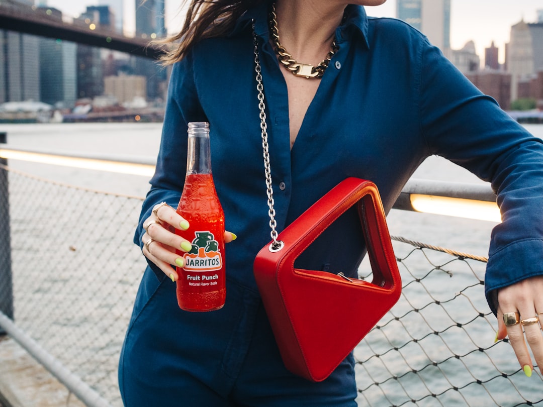 woman in blue dress shirt holding red plastic container