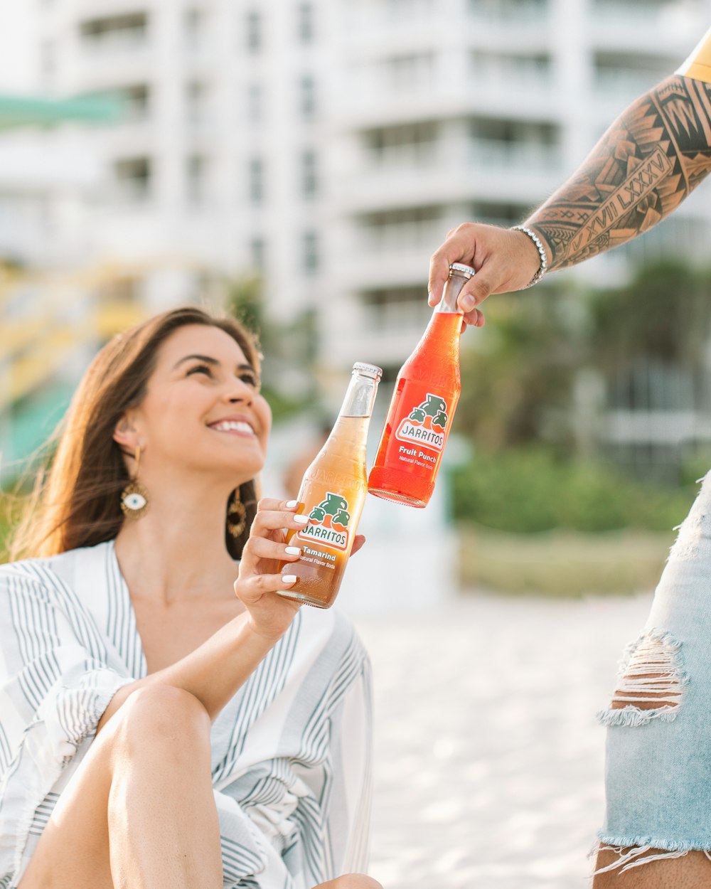 woman in white dress holding orange bottle