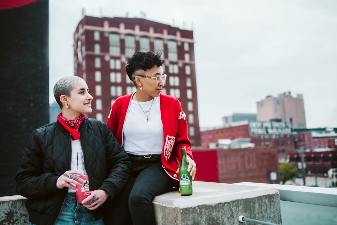 man in red polo shirt and black jacket sitting beside woman in black jacket