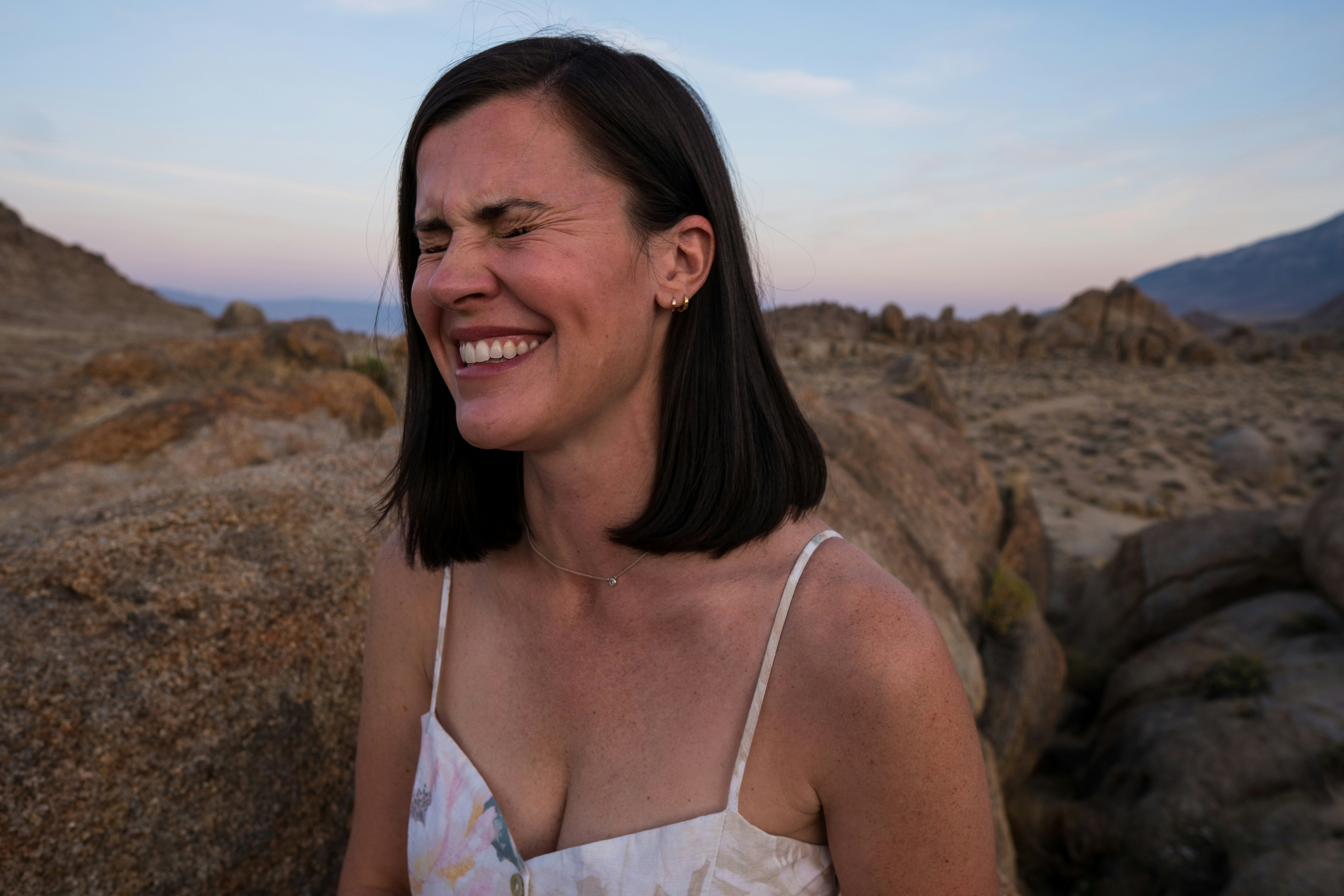 woman in white spaghetti strap top smiling