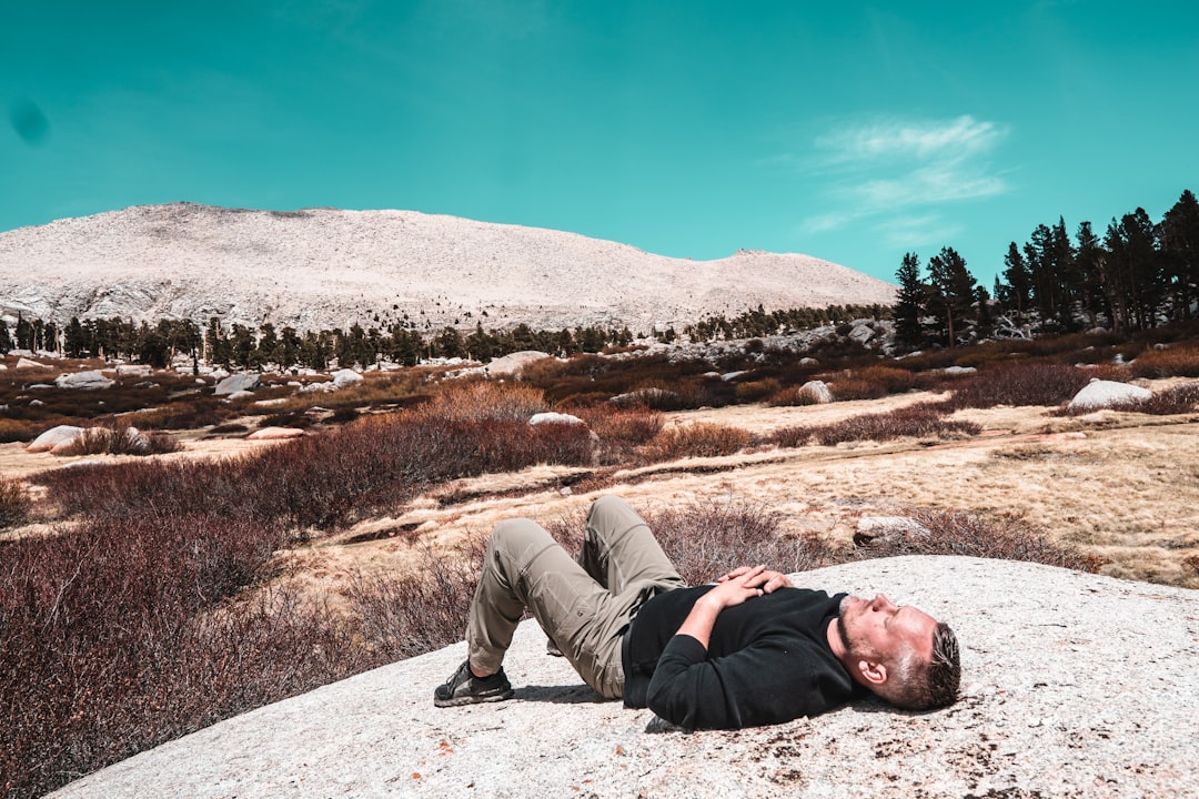 man in black shirt lying on ground during daytime