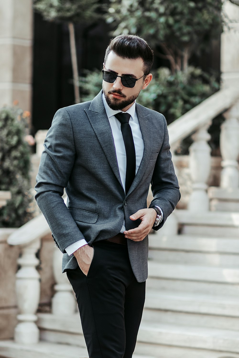 man in gray suit jacket and black pants wearing black sunglasses standing  on gray concrete stairs photo – Free Tehran Image on Unsplash