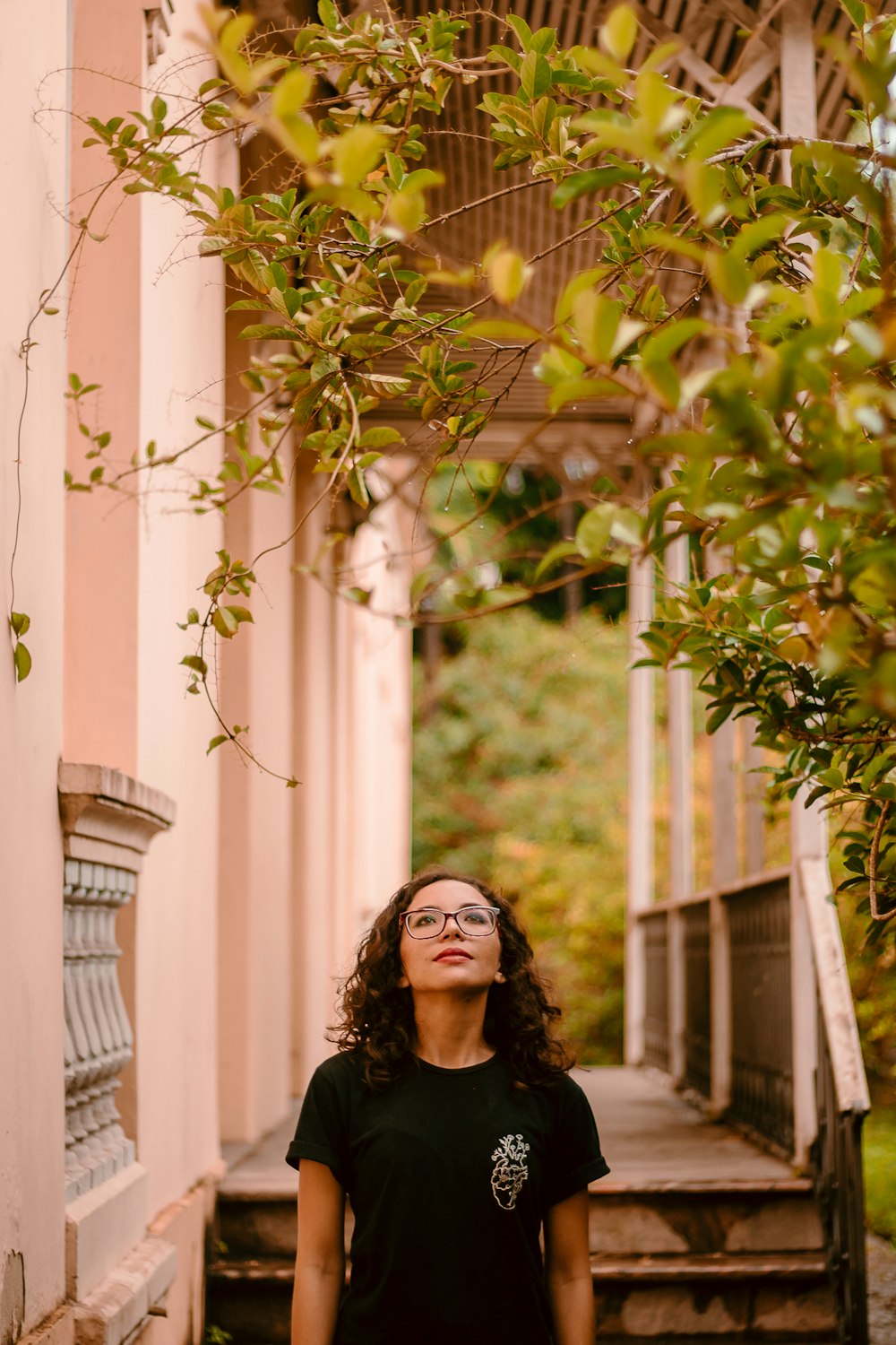 woman in black shirt standing near green tree during daytime