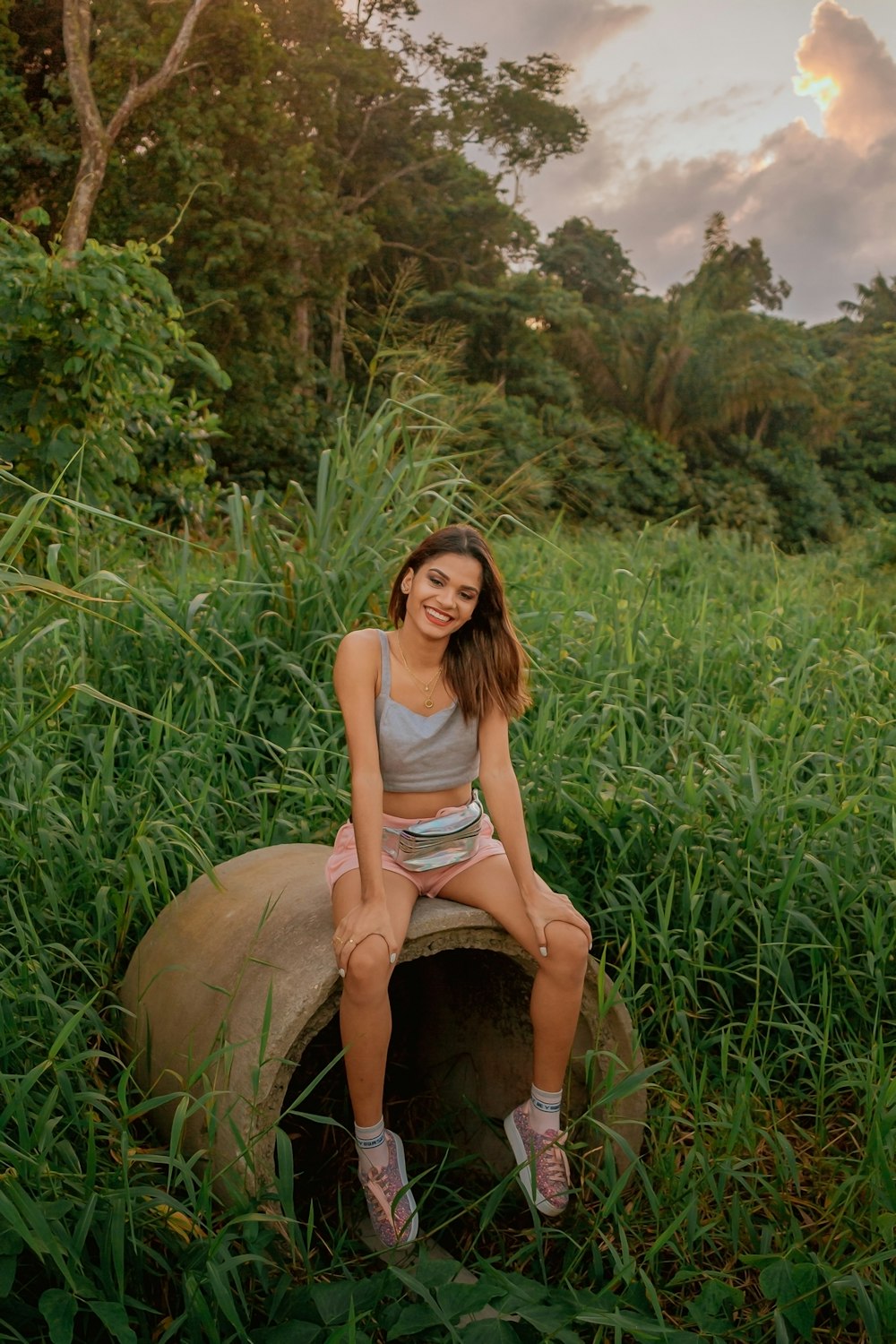 woman in pink tank top sitting on brown rock