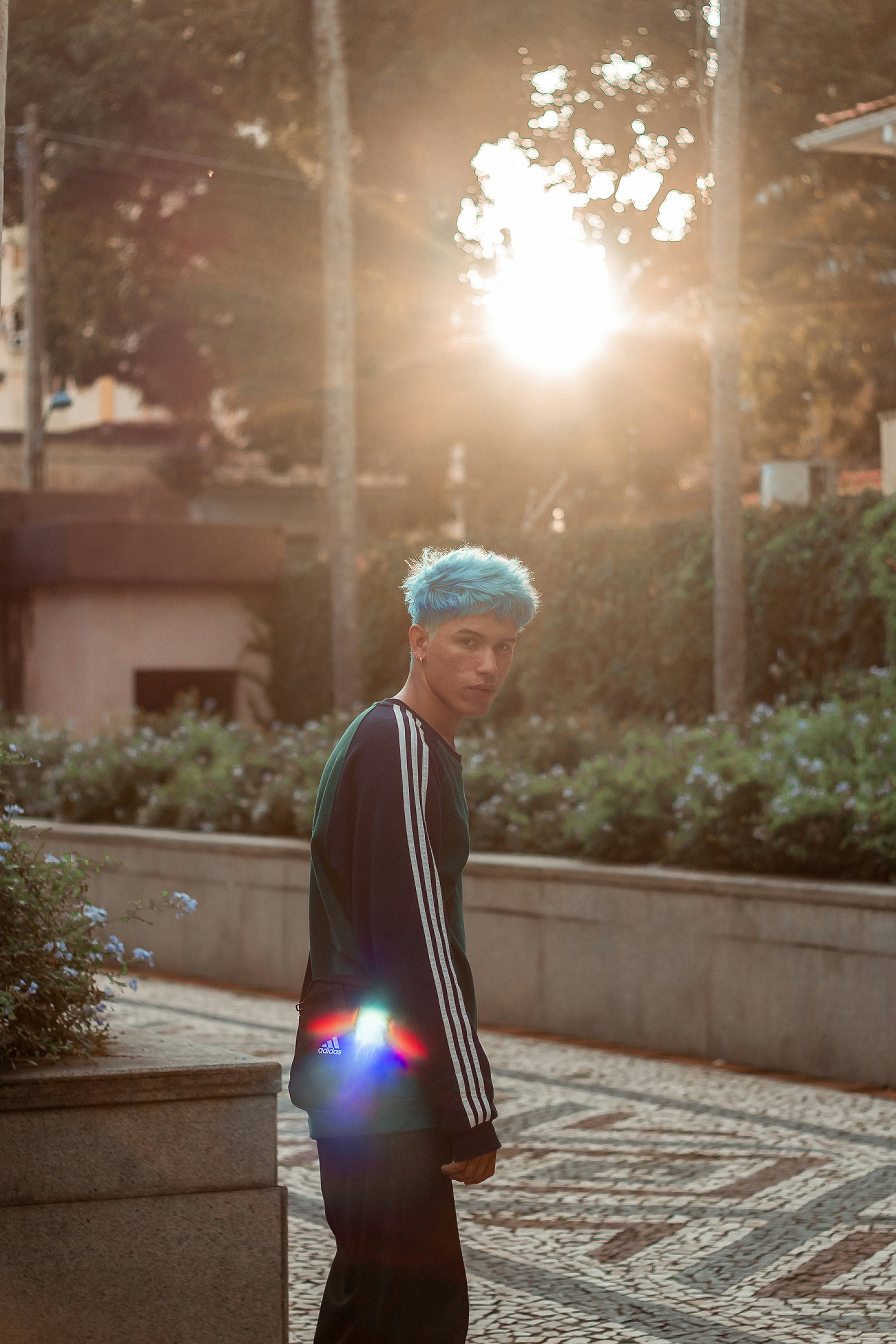 man in black and white jacket standing on sidewalk during daytime