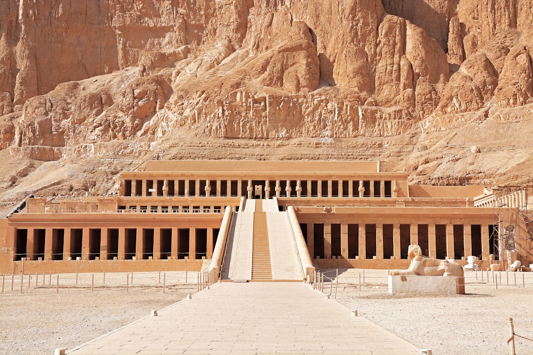 white concrete building near brown rock formation during daytime