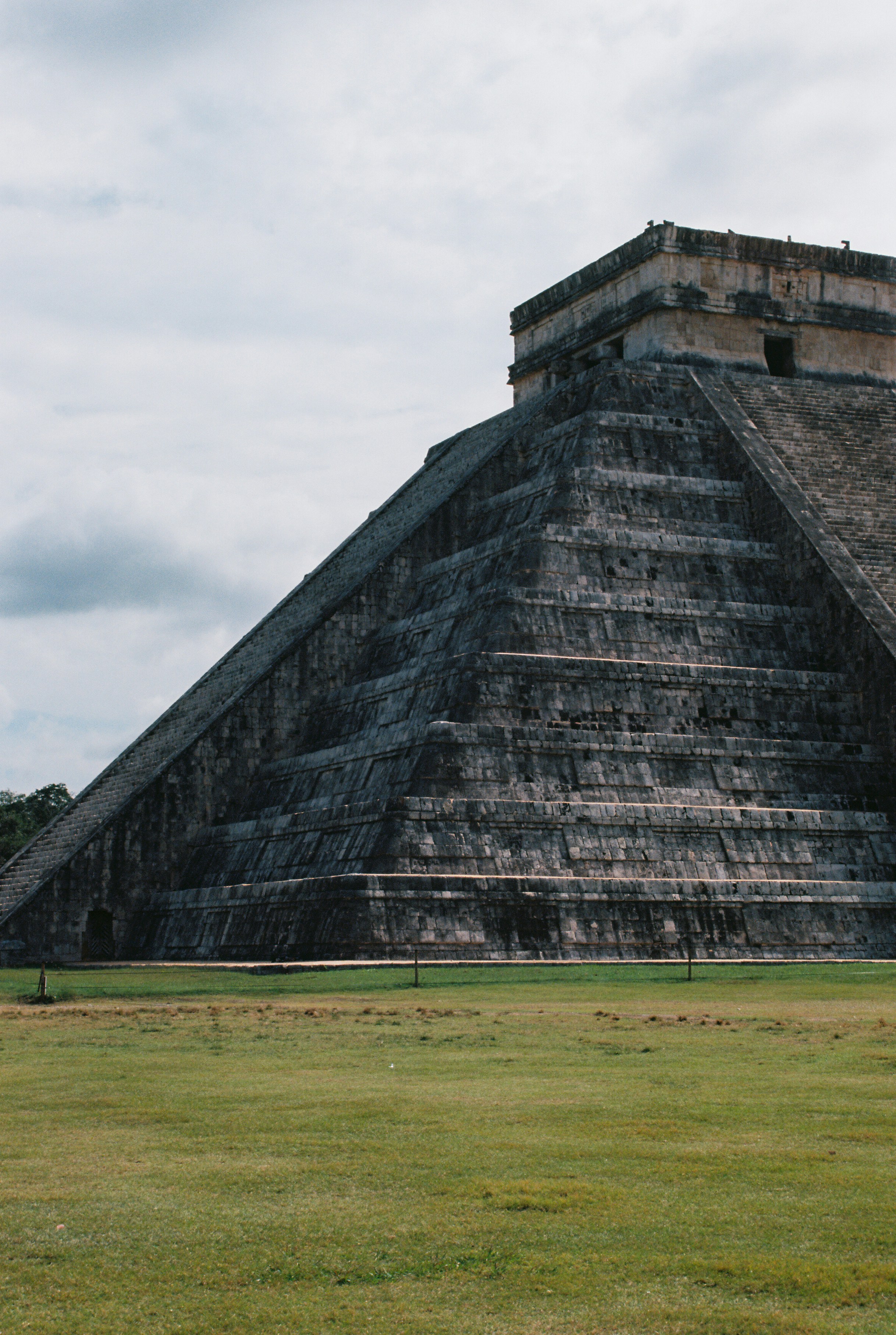 gray concrete building on green grass field under gray sky during daytime