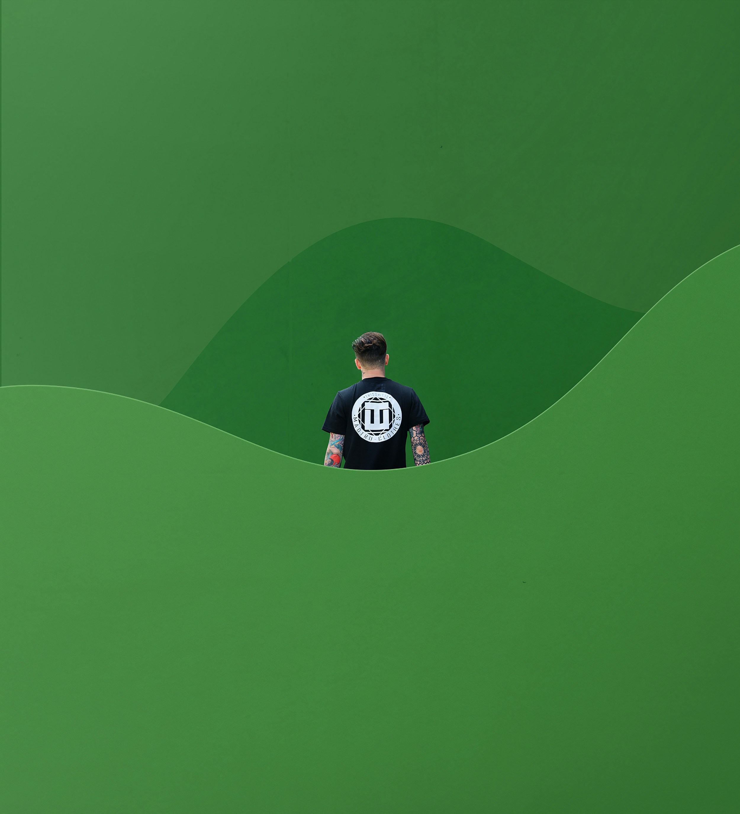 a man standing in front of a green wall