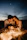 A couple enjoying a private beach dinner with lanterns glowing softly around them at twilight.