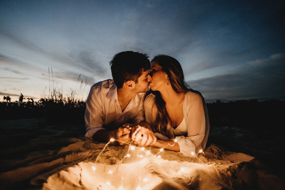 夜の茶色の砂浜でキスをする男女