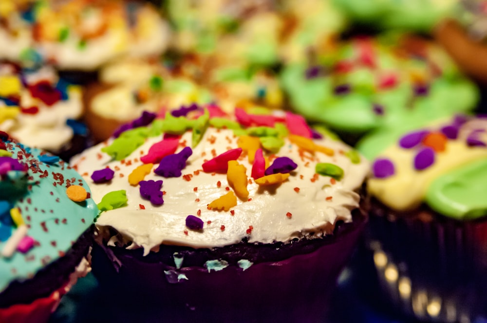 brown cupcake with white icing and sprinkles