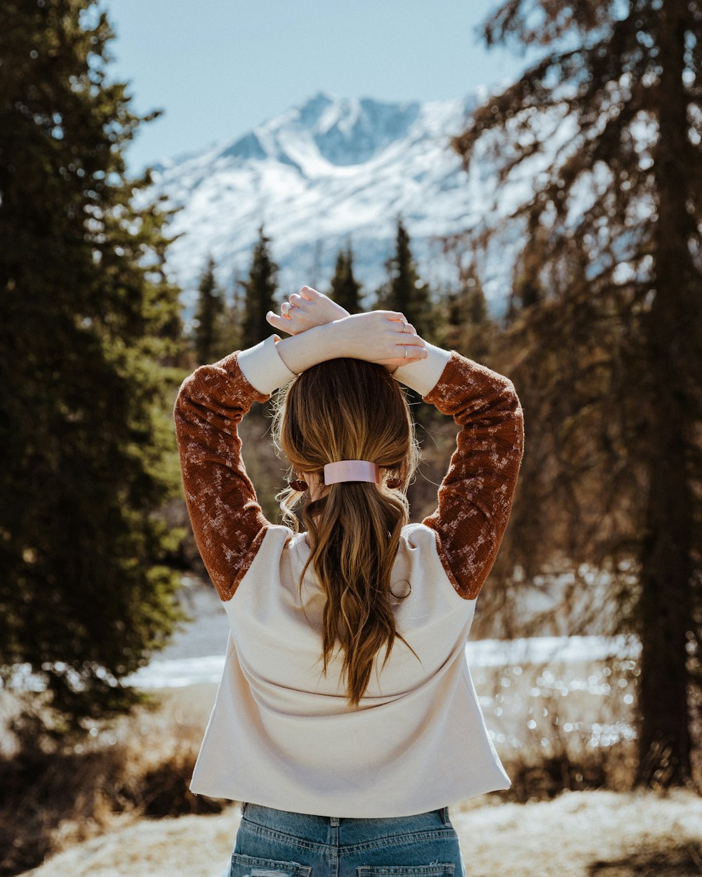 a woman standing in the snow with her hands on her head