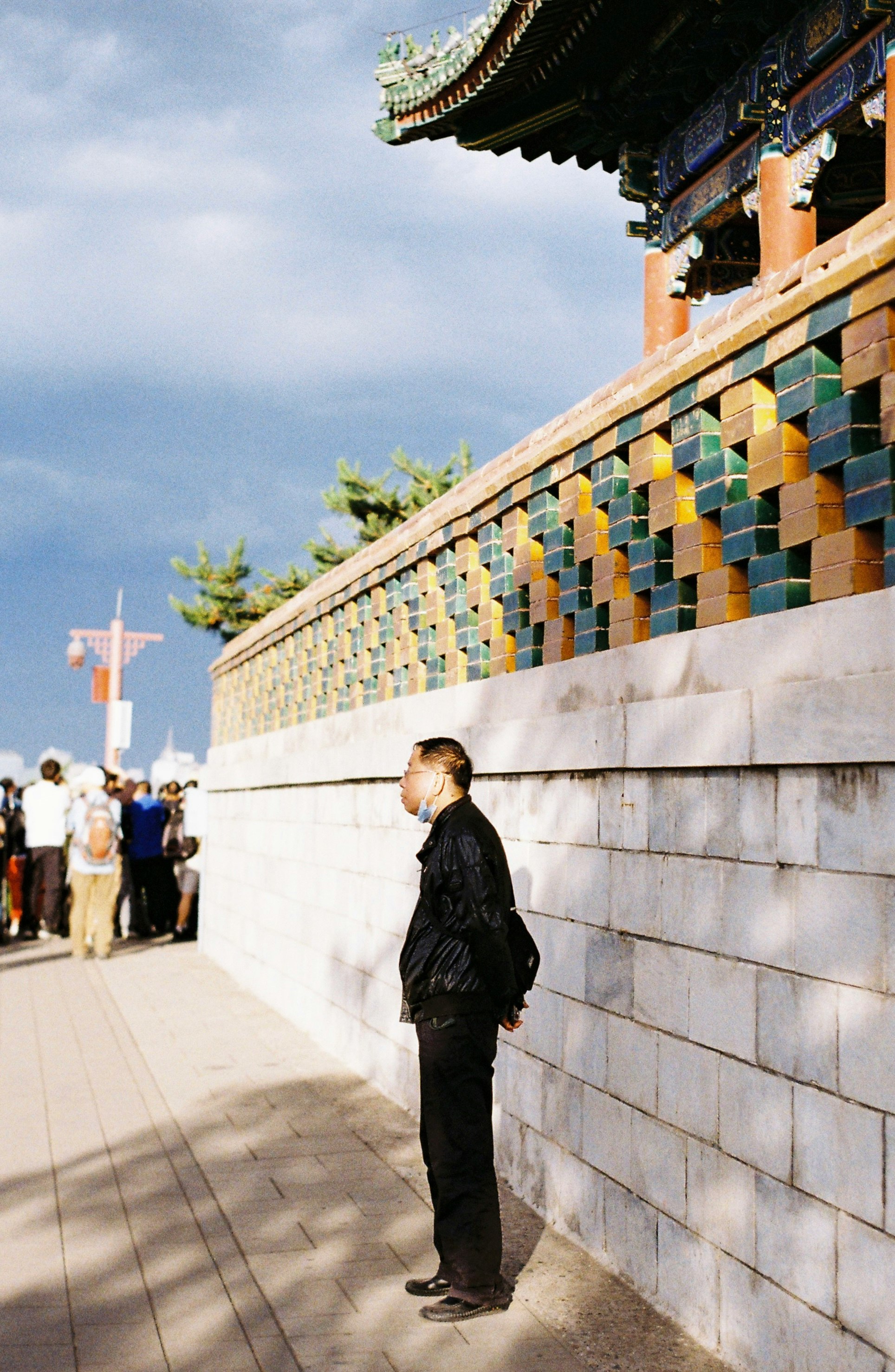 woman in black jacket standing near white concrete building during daytime