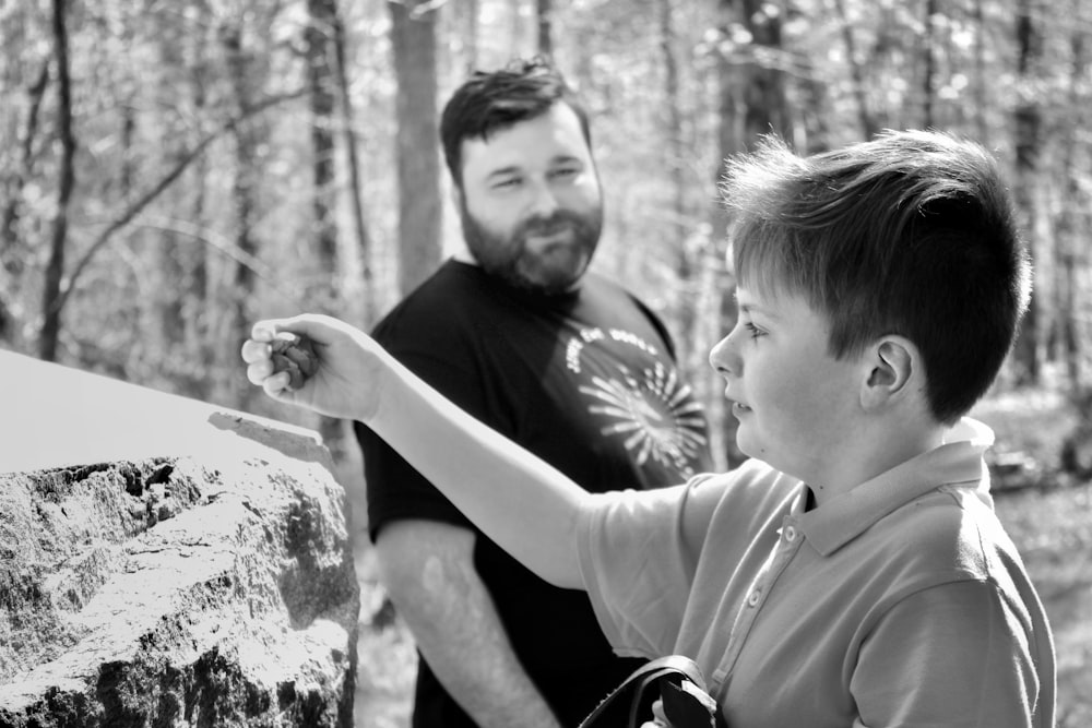 man in black long sleeve shirt carrying boy in black jacket