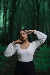 woman in white long sleeve shirt covering her face with her hands