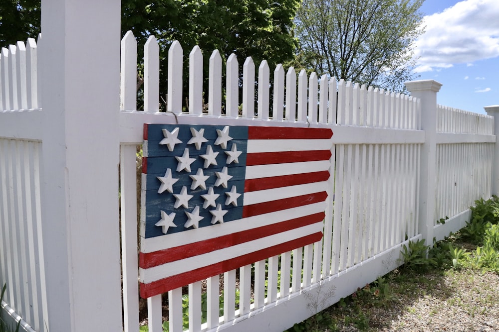 us a flag on white wooden fence