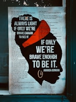 A text poster with a silhouette of a woman's head filled with text. Overlaid on the silhouette are bold white letters stating, 'There is always light if only we're brave enough to see it. If only we're brave enough to be it.' The rest of the poster displays an excerpt from a poem in the background.