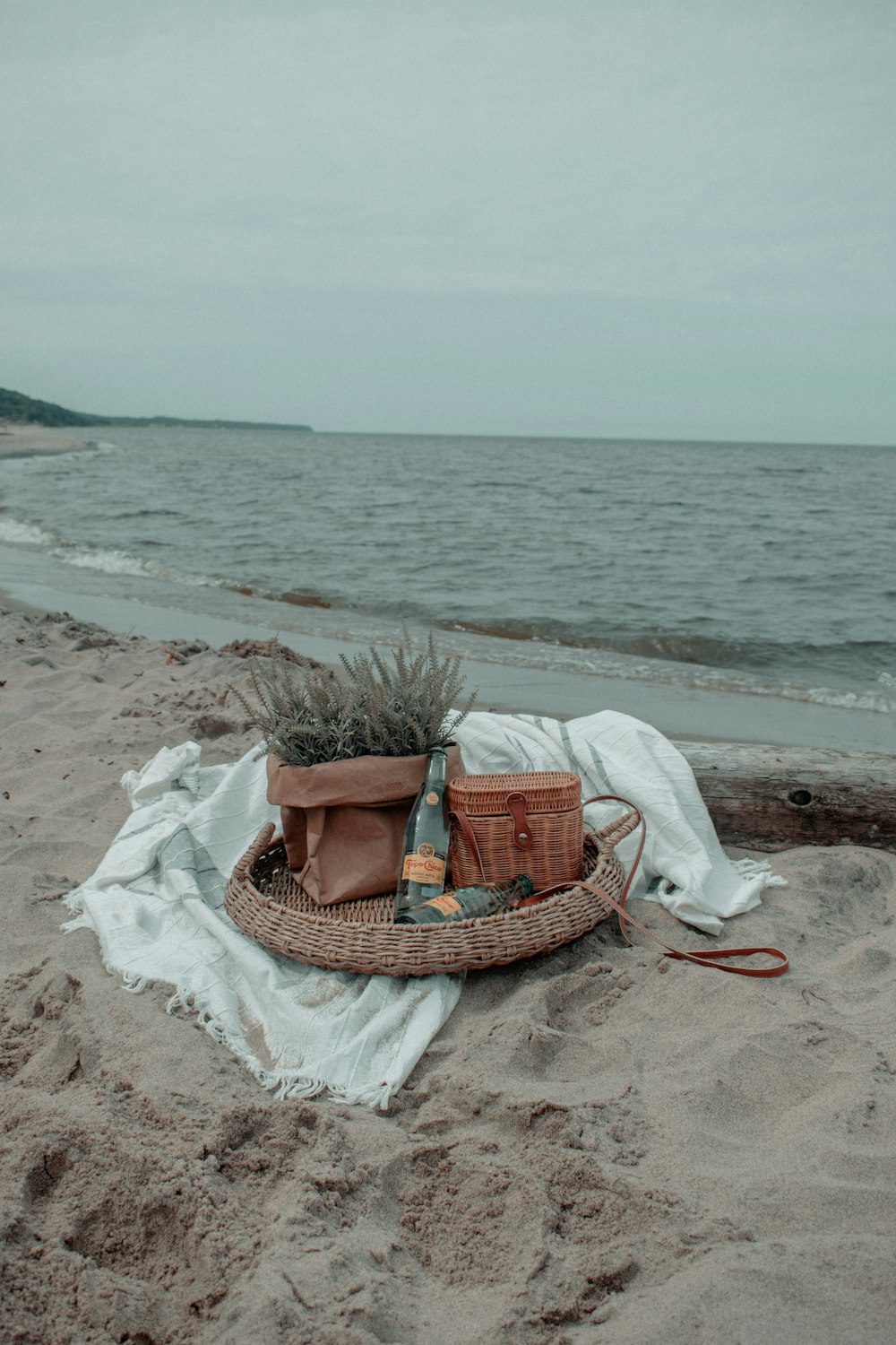 brown woven basket on white textile on beach during daytime