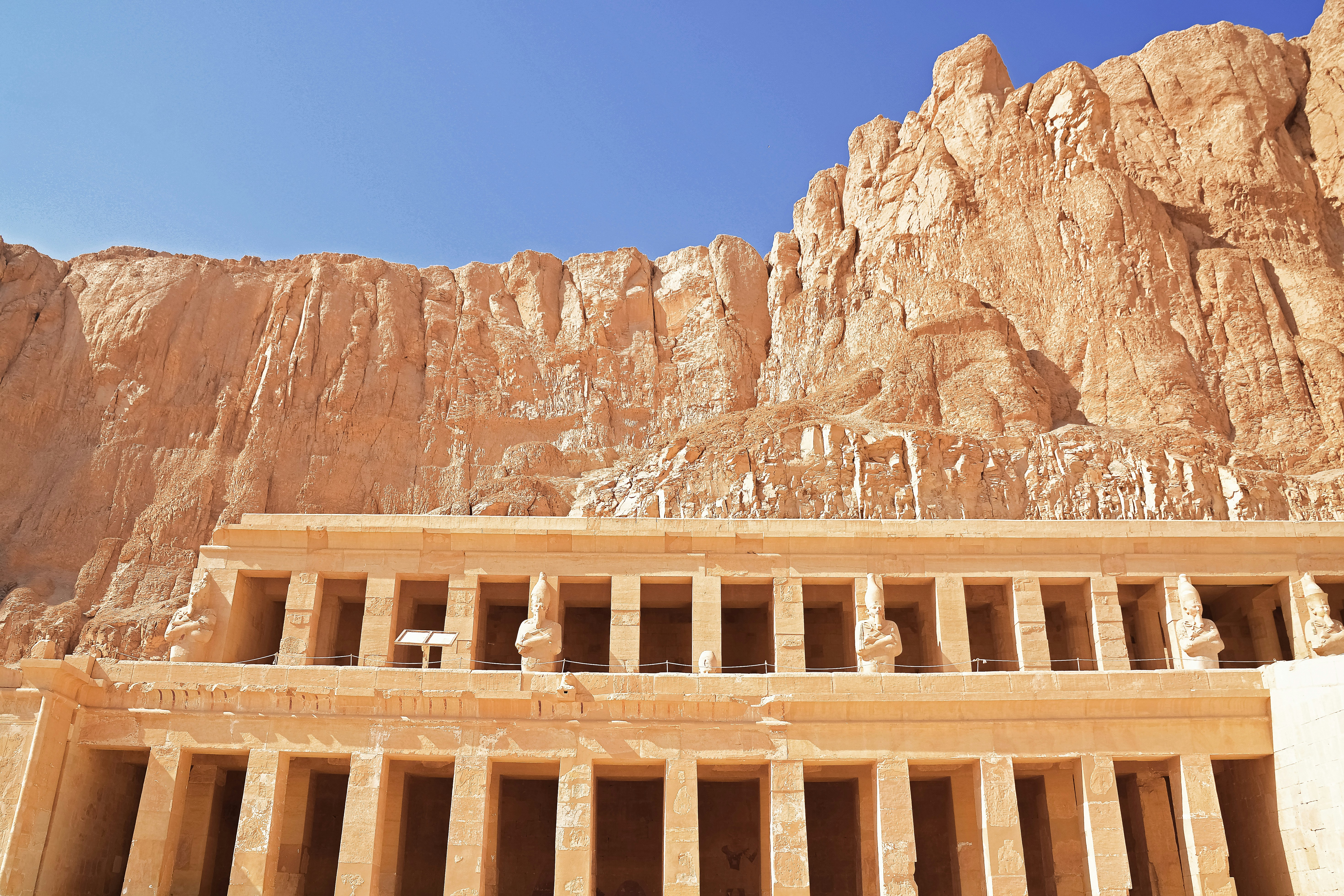 brown concrete building near brown rocky mountain under blue sky during daytime