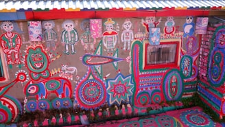 A vibrant mural with cacti and natural elements decorating the exterior wall of Giramundo Hostel in Humahuaca.