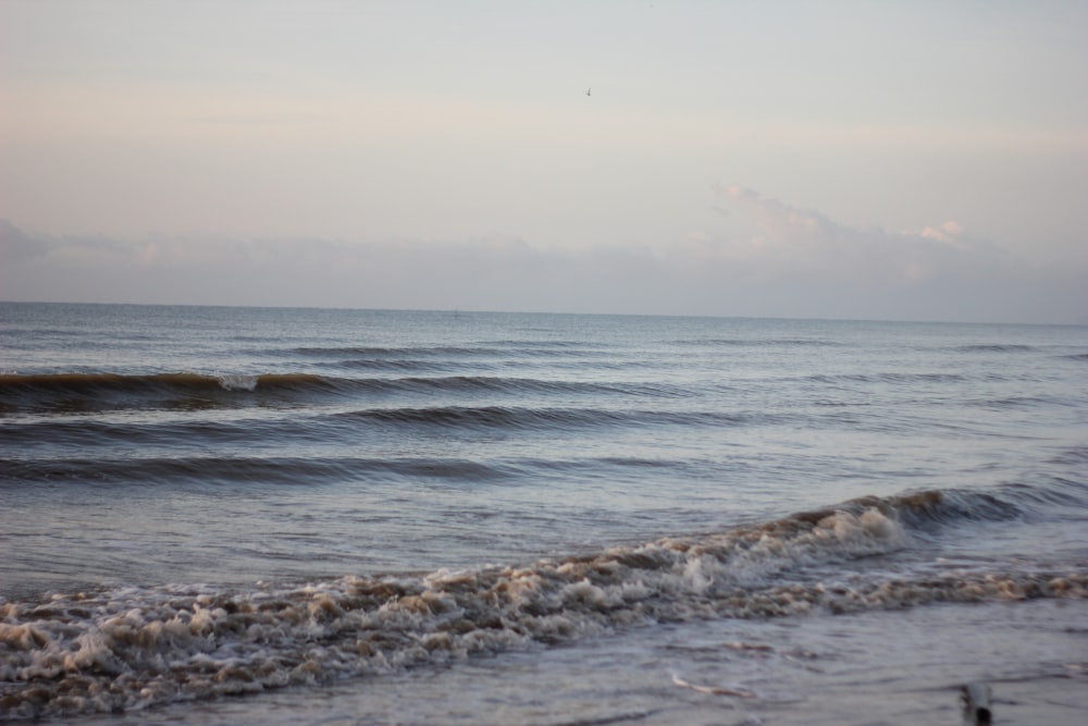 sea waves crashing on shore during daytime