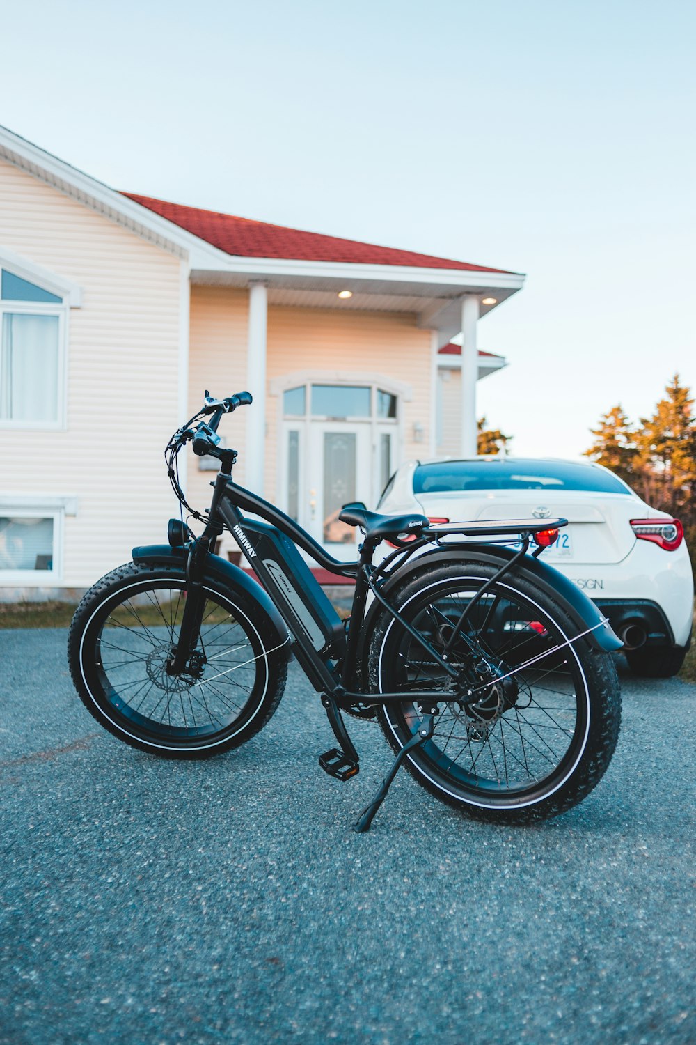 black and blue cruiser motorcycle parked beside white car during daytime