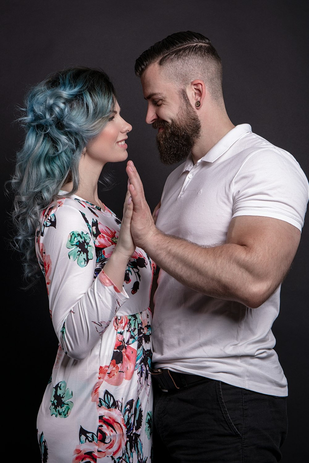 man in white crew neck t-shirt holding woman in white and red floral dress