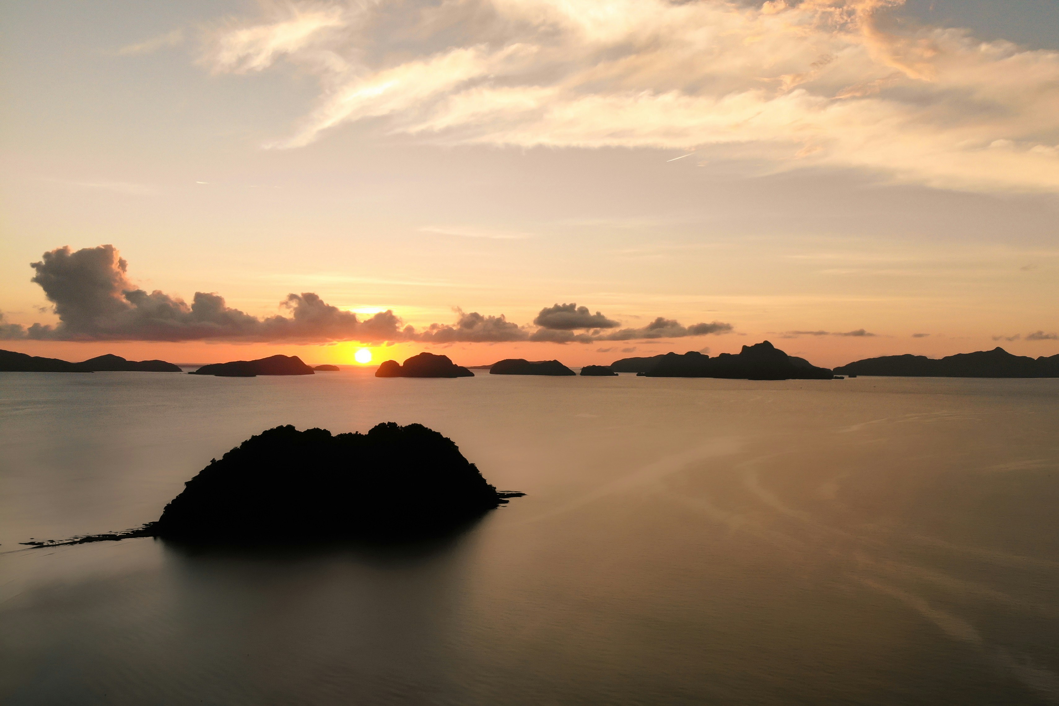 silhouette dell'isola sullo specchio d'acqua durante il tramonto