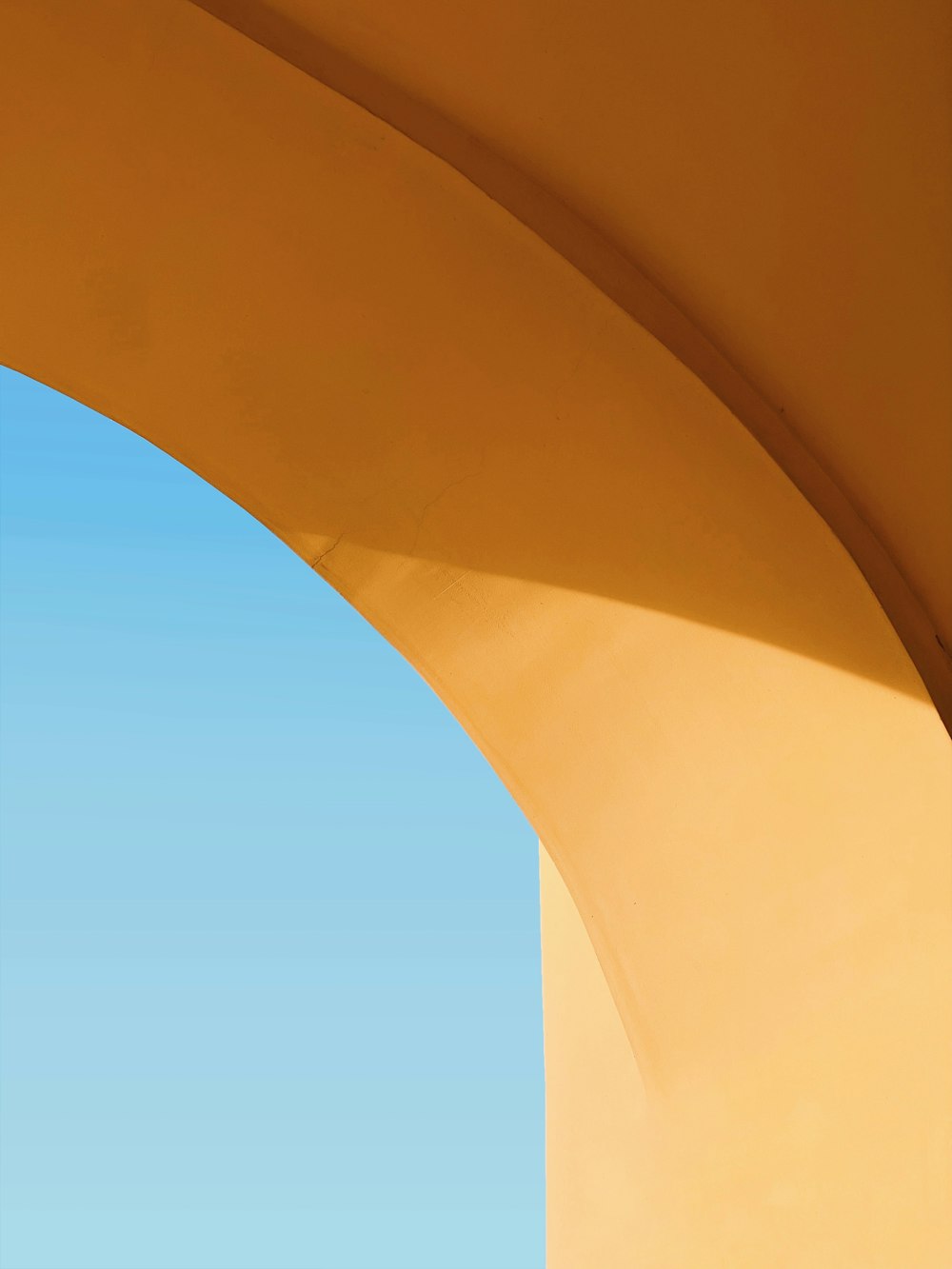 Bâtiment en béton brun sous le ciel bleu pendant la journée