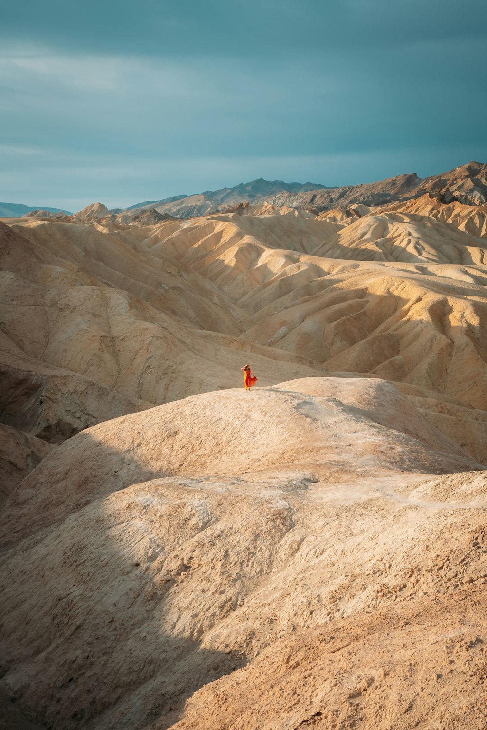 pessoa na camisa vermelha em pé na formação rochosa marrom durante o dia