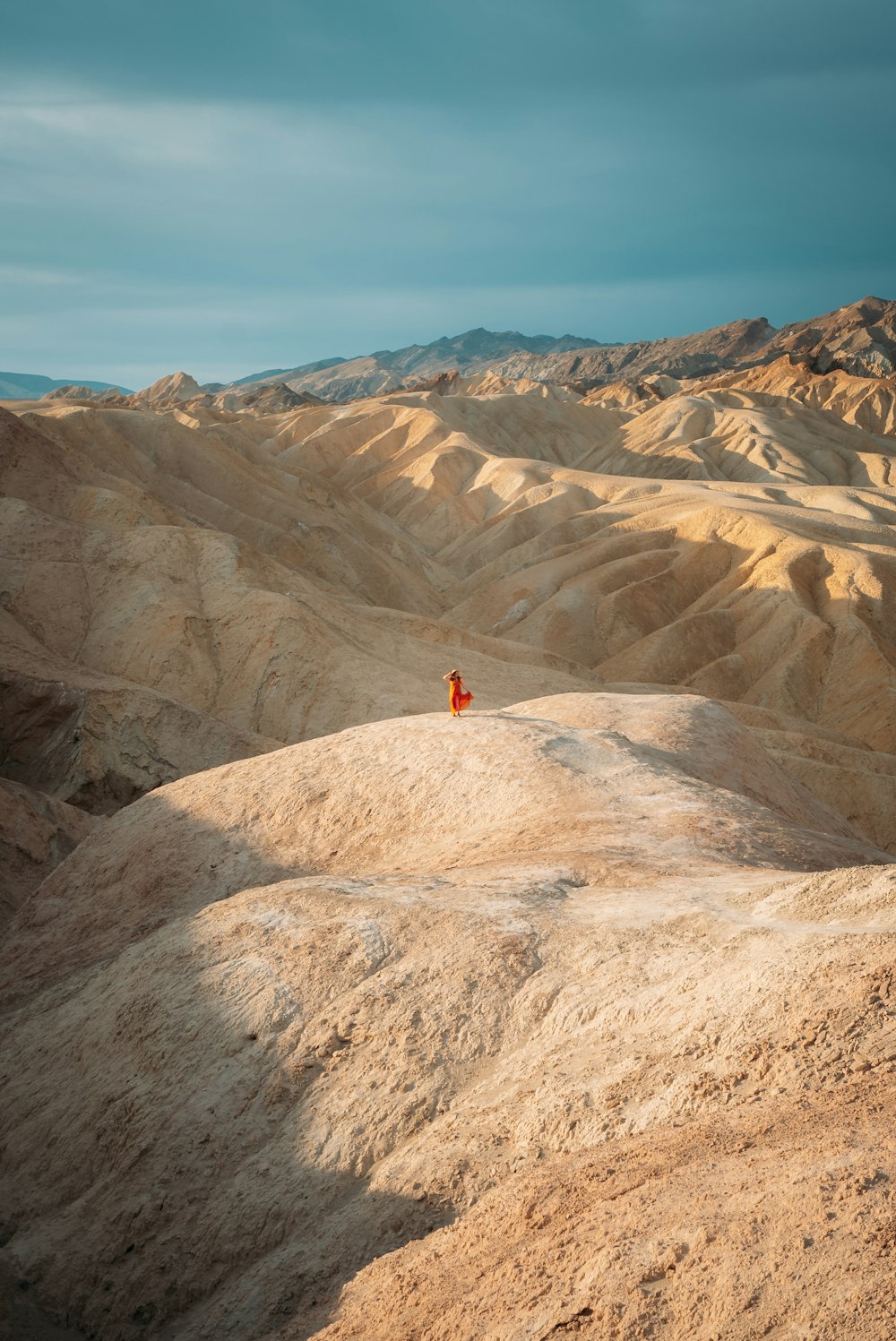 person in red shirt standing on brown rock formation during daytime