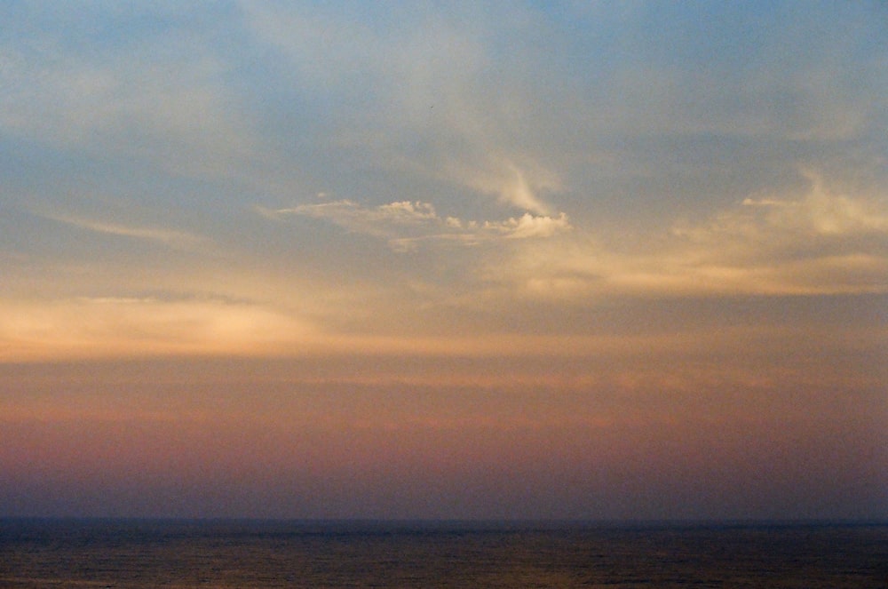 body of water under cloudy sky during daytime