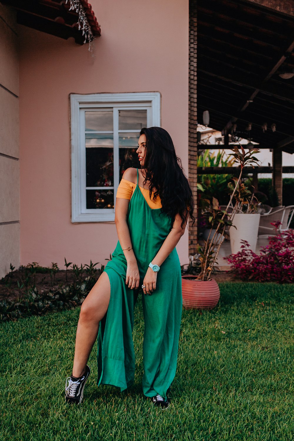 woman in red sleeveless dress standing on green grass field during daytime