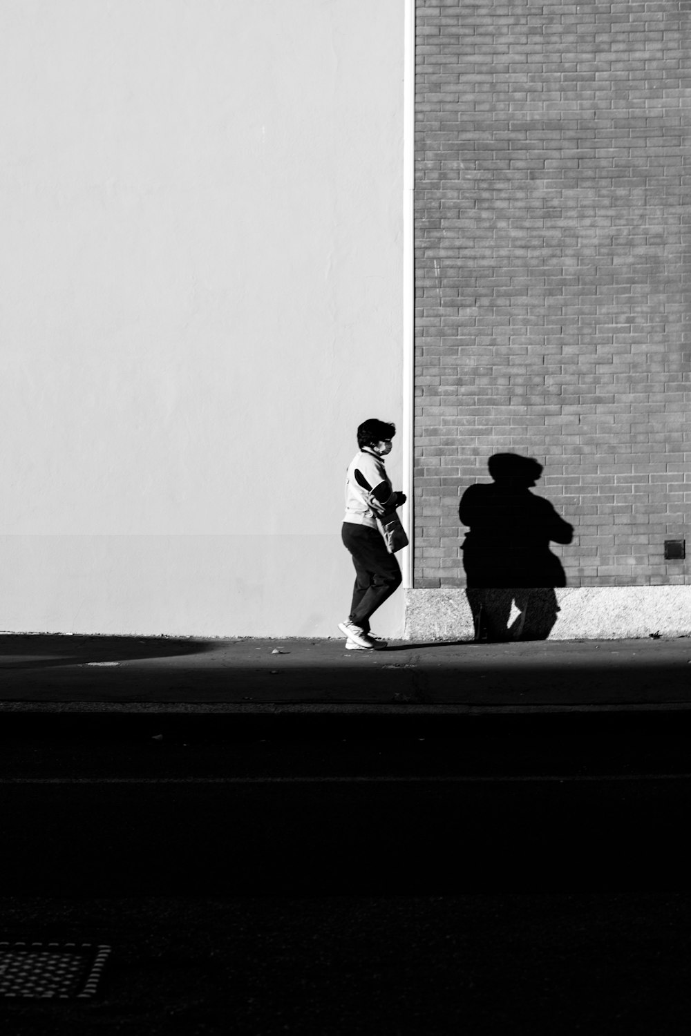 2 men walking on sidewalk in grayscale photography
