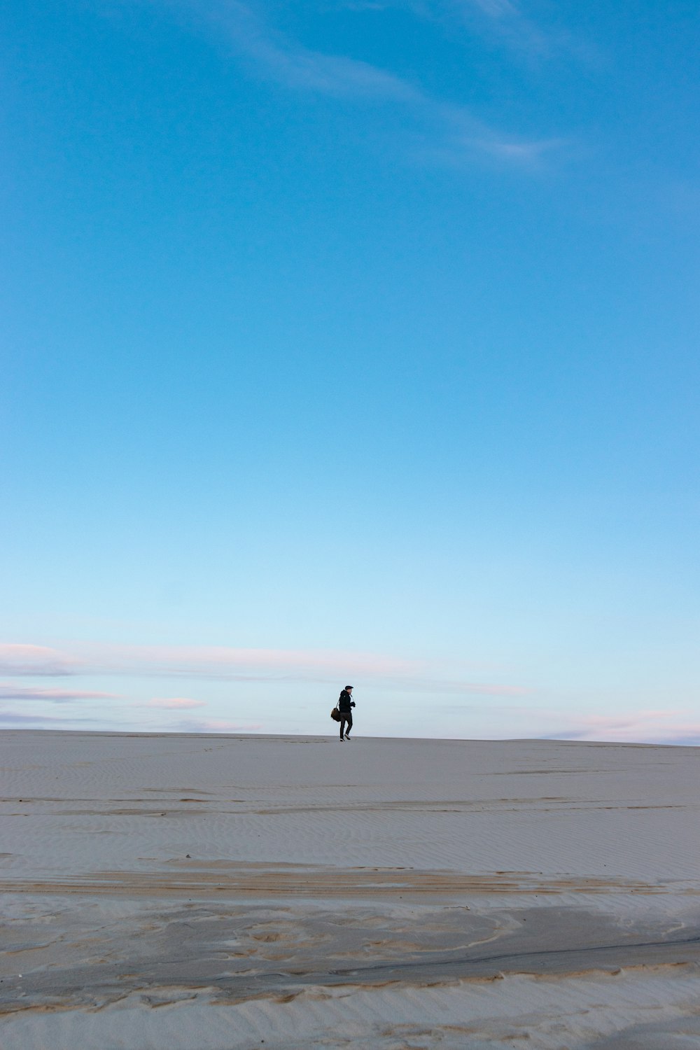 person walking on gray sand during daytime