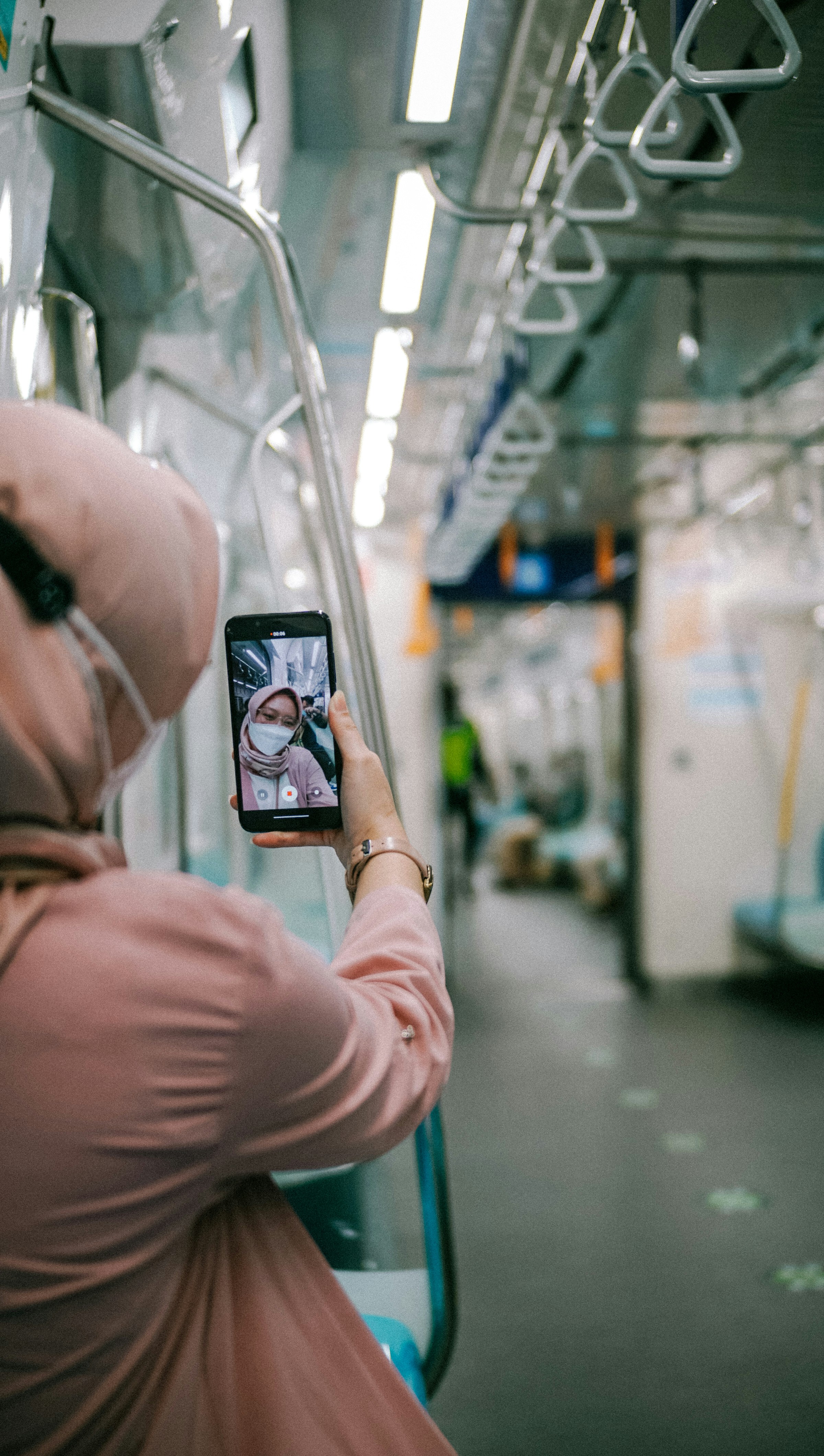 鏡の写真を撮る黒いスマートフォンを持っている人