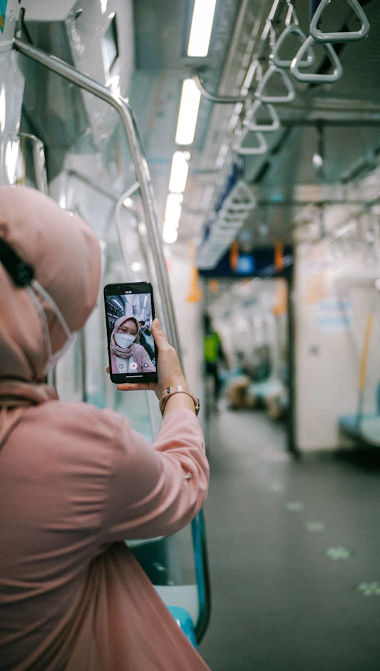 person holding black smartphone taking photo of mirror