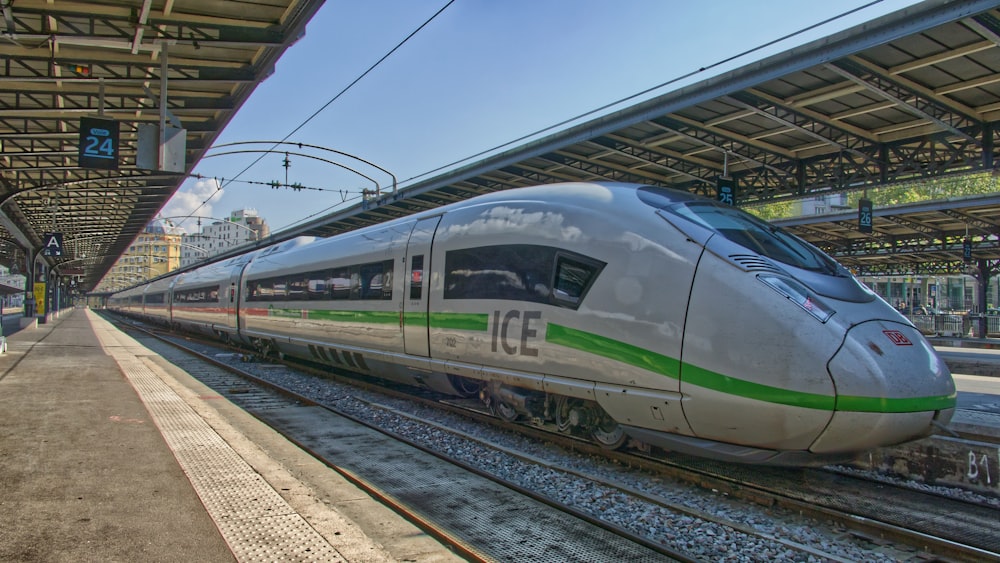 white and green train on rail tracks during daytime