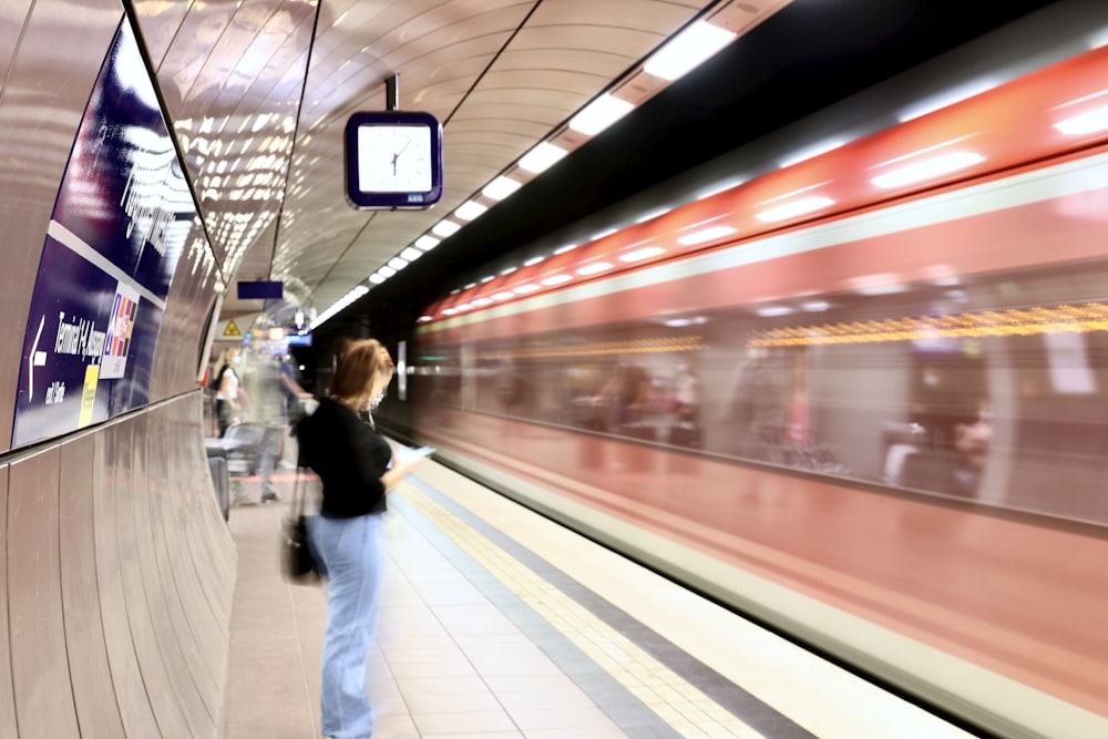 man in black jacket and blue denim jeans walking on white ceramic floor tiles