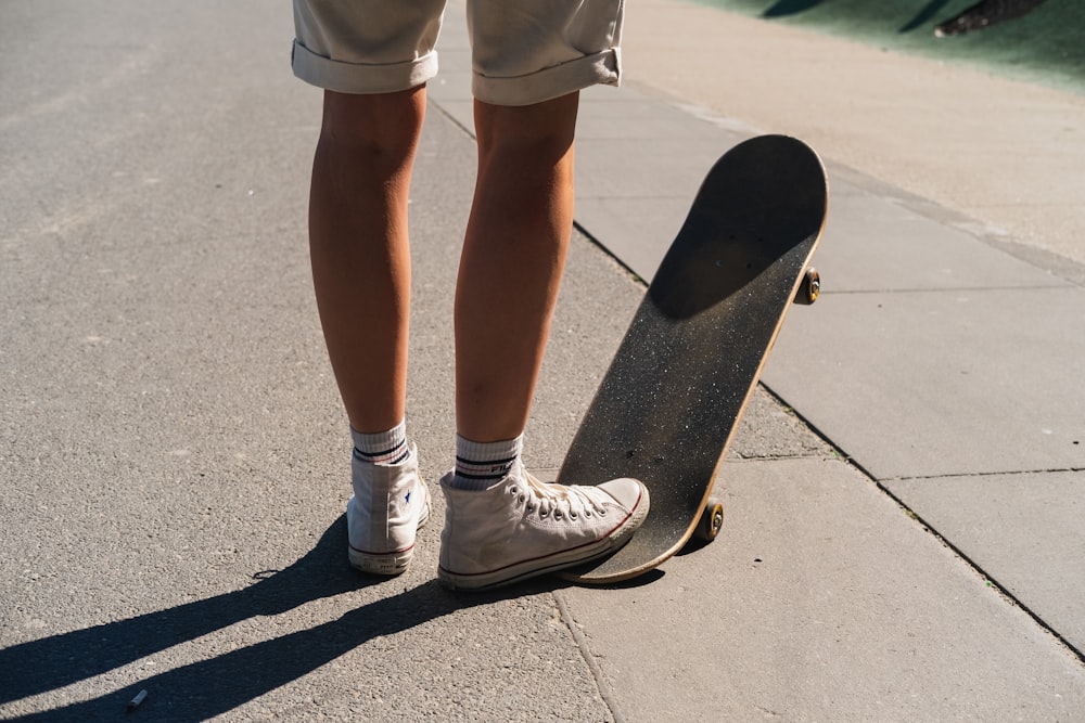 person in white shorts and white nike sneakers